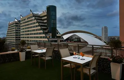 two tables and chairs on the roof of a building at NH Valencia Las Artes in Valencia