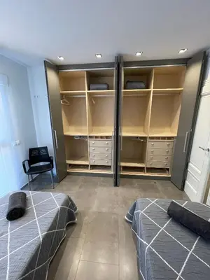 a bedroom with two beds and a closet with shelves at PRIMERA LINEA PLAYA PATACONA, VALENCIA in Valencia