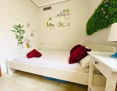 a white bed with red pillows in a room at PENTHOUSE on the BEACH in Valencia