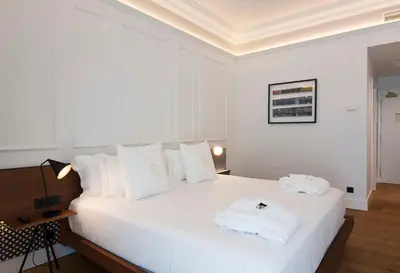 a bedroom with a white bed with white pillows at One Shot Reina Victoria in Valencia
