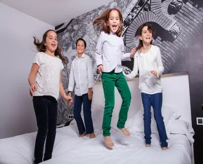 a group of children jumping on a bed at Hotel Dimar in Valencia