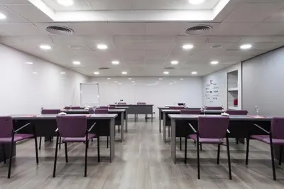 a conference room with tables and purple chairs at Hotel Dimar in Valencia