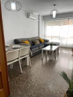 a living room with a couch and a table at UIM Mediterraneo Claveles Wifi in Puerto de Sagunto
