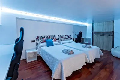 a bedroom with a large white bed with blue lighting at Loft Nou Benicalap - Housevanlive in Valencia