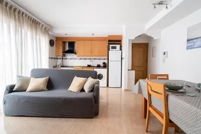 a living room with a couch and a table at Excelente apartamento en 2ª línea de playa by Hometels in Puerto de Sagunto