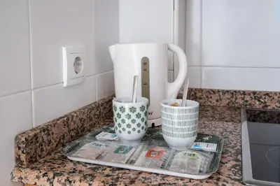 a kitchen counter with two cups and a blender at Excelente apartamento en 2ª línea de playa by Hometels in Puerto de Sagunto