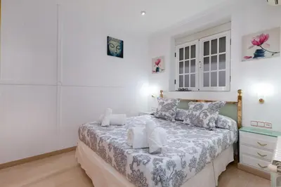 a bedroom with a large bed with white walls at Malvarrosa Las Arenas I in Valencia