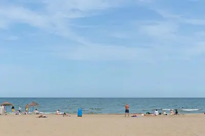 a group of people on a beach with the ocean at Malvarrosa Las Arenas I in Valencia