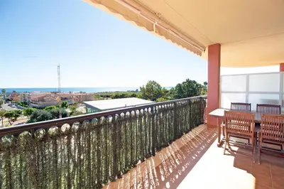 a balcony with a table and chairs on it at Global Vacacional, Apartamento con gran terraza y piscina in Canet de Berenguer