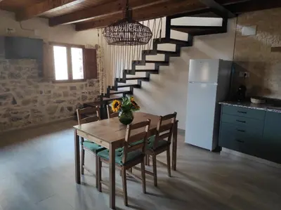 a kitchen with a table and chairs and a staircase at Casa el Recreo in Jérica