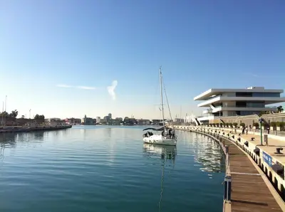 a boat in the water next to a dock at Malvarrosa Las Arenas II in Valencia