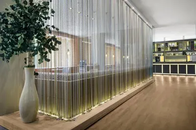 a room with a large glass wall with a vase with a plant at AC Hotel Valencia by Marriott in Valencia