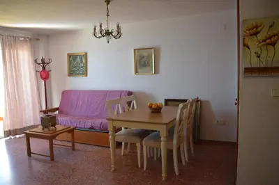a living room with a table and a purple couch at Apartamento Florazar 2, 10ºC Cullera in Faro de Cullera