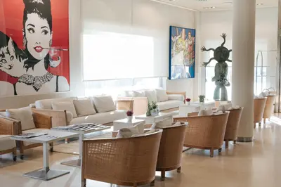 a living room with couches and tables and chairs at Hotel Neptuno Playa & Spa in Valencia
