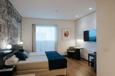 a hotel room with a bed and a flat screen tv at Hotel Neptuno Playa & Spa in Valencia