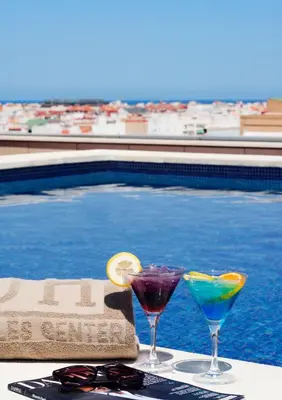 two cocktails on a table next to a swimming pool at Hotel Valencia Center in Valencia