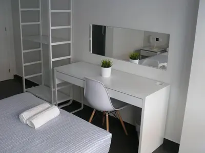 a room with a desk and a bed and a mirror at HOSTAL LETTO DAL MARE in Valencia