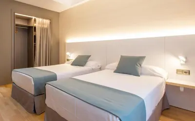 two beds in a hotel room with two beds at Hotel Olympia Valencia in Alboraya
