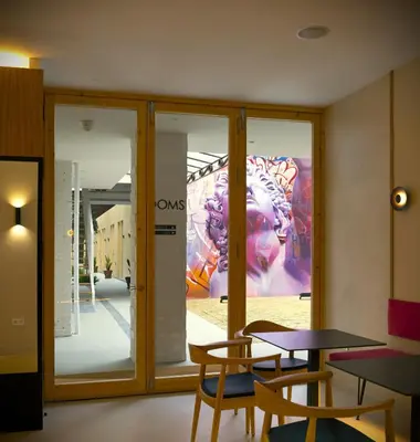 a room with tables and chairs and a painting on the wall at Mythic Valencia in Valencia