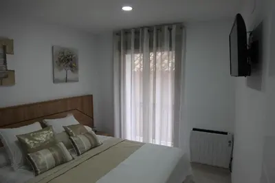 a bedroom with a bed with a television and a window at Apartamentos Alogia, Pastora, Yerbater in Segorbe