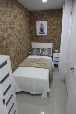 a bedroom with a bed and a stone wall at Apartamentos Alogia, Pastora, Yerbater in Segorbe