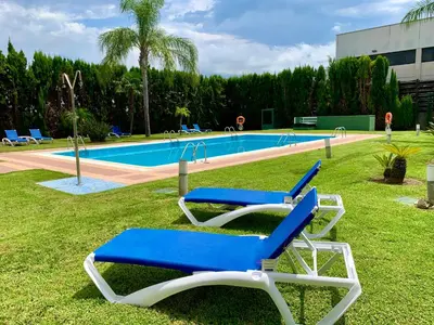 two blue and white lounge chairs in front of a swimming pool at Ramada by Wyndham Valencia Almussafes in Almussafes