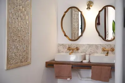 a bathroom with two sinks and mirrors on the wall at El mas allà in Chulilla