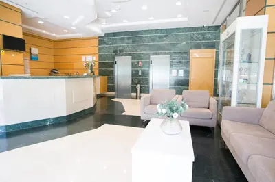 a waiting room with couches and a table with flowers at Hotel Albufera in Alfafar