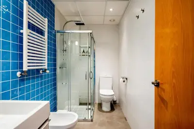 a bathroom with a toilet and a glass shower at Moderno apartamento con vistas al mar en Valencia in Valencia