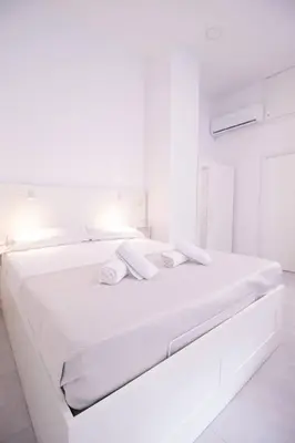 a white bedroom with a white bed with two white towels at Viveros by Concept Flats in Valencia