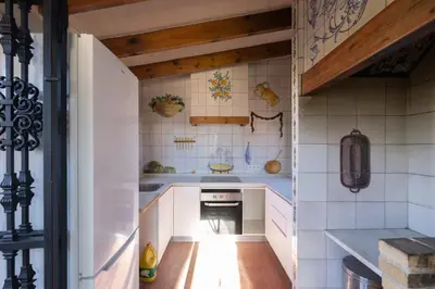 a kitchen with white tiled walls and wooden ceilings at Villa Huerta 1 Manises, jacuzzi, sauna, piscina in Manises