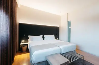 a bedroom with a large white bed and a table at Barceló Valencia in Valencia