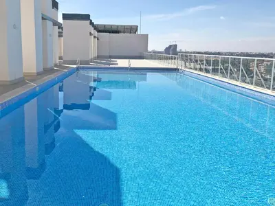 a large blue swimming pool on top of a building at Global Vacacional, Moderno apartamento en Canet al Mar in Canet de Berenguer