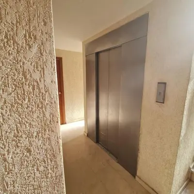 a hallway with a metal door in a building at Precioso apartamento en Cullera, con piscina junto a la playa in Cullera