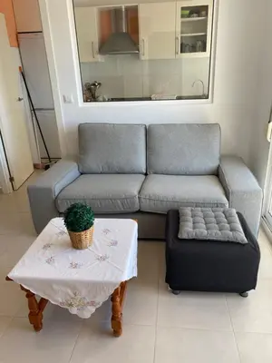 a living room with a couch and a table at Apartamento junto a playa y cerca de campo de golf in El Perellonet