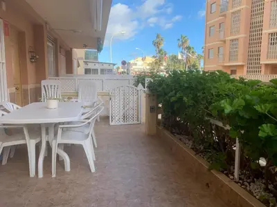 a white table and chairs on a patio at Apartamento en la playa in Tavernes de Valldigna