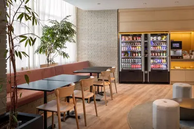 a restaurant with tables and chairs and a drink refrigerator at B&B HOTEL Valencia Arena in Valencia