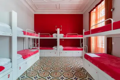 a room with red walls and white bunk beds at Red Nest Hostel in Valencia