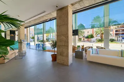 a lobby with a couch and some plants and windows at Sea You Hotel Port Valencia in Valencia