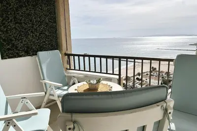 a balcony with chairs and a view of the beach at The Beach Apartment in El Puig