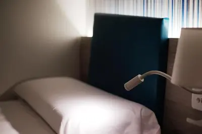 a bedroom with a bed with a lamp on it at Hotel Mediterraneo Valencia in Valencia