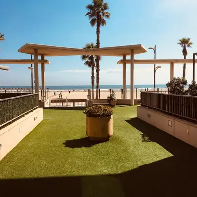 a view of the beach with palm trees and a pavilion at FiveStepsToSea - Beach Apartment Valencia in Valencia