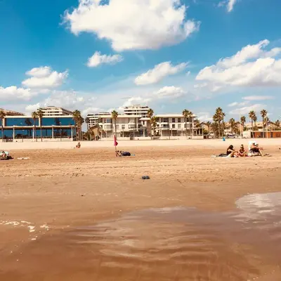 a group of people sitting on the beach at FiveStepsToSea - Beach Apartment Valencia in Valencia