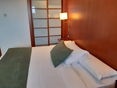 a bedroom with a white bed with a green pillow at Hotel Xon's Valencia in Aldaya