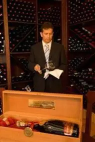 a man standing at a podium in a wine cellar at Hotel Rioja in Benisanó