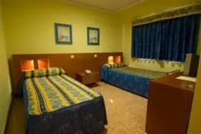 a hotel room with two beds and a desk at Hotel Rioja in Benisanó