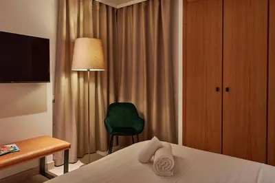 a hotel room with a bed and a green chair at Sea view modern flat in Alboraya