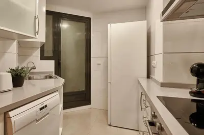 a white kitchen with a sink and a refrigerator at Sea view modern flat in Alboraya