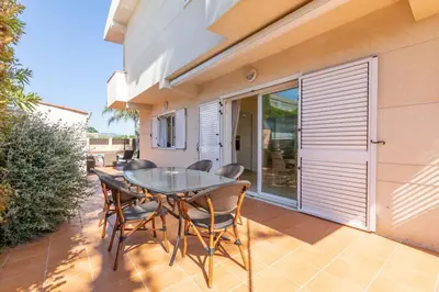 a patio with a table and chairs on a balcony at Casa junto al mar con jardín in Sagunto