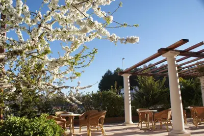 a patio with tables and chairs under a pergola at Hotel Patilla Ciudad de Requena in Requena
